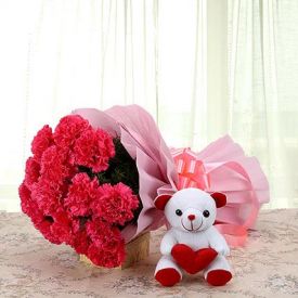 A bunch of Red carnations, and white cute teddy bear